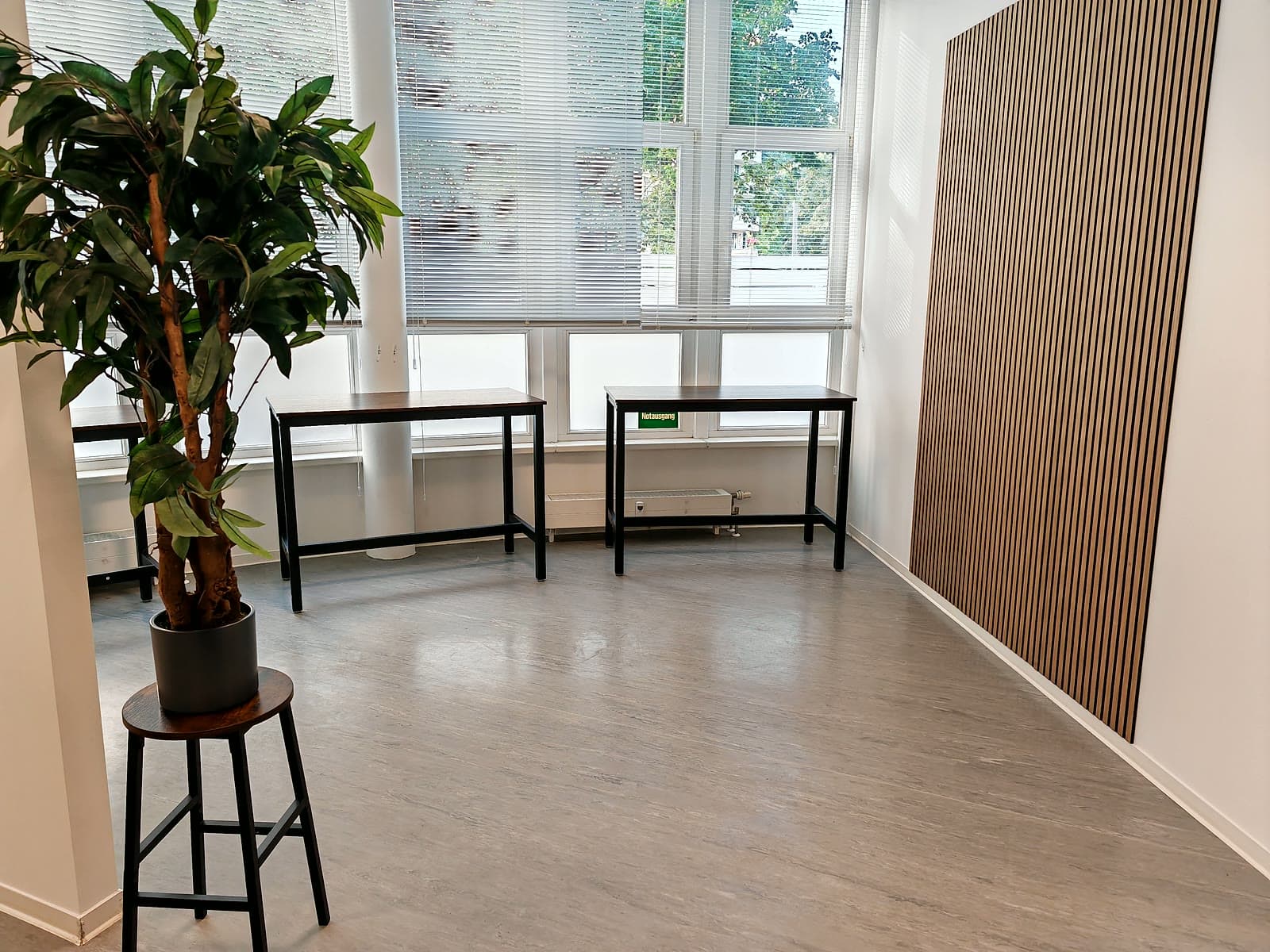 Arbeitsbereich mit Stehtischen und Akustikwand am Berliner Standort
